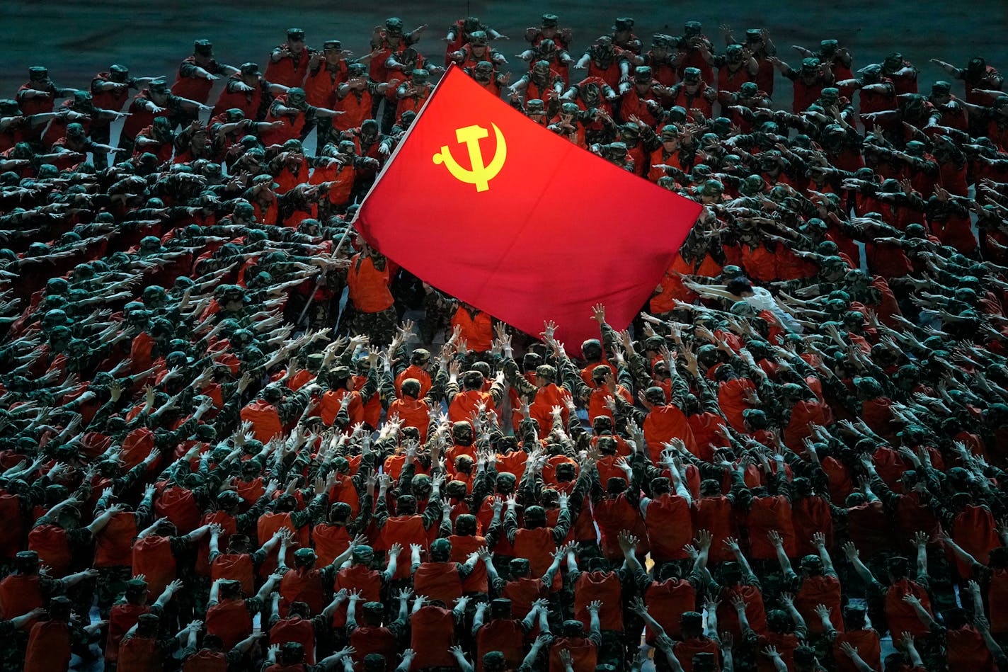 Performers dressed as rescue workers gather around the Communist Party flag during a gala show ahead of the 100th anniversary of the founding of the Chinese Communist Party in Beijing on Monday, June 28, 2021. China is marking the centenary of its ruling Communist Party this week by heralding what it says is its growing influence abroad, along with success in battling corruption at home. (AP Photo/Ng Han Guan)