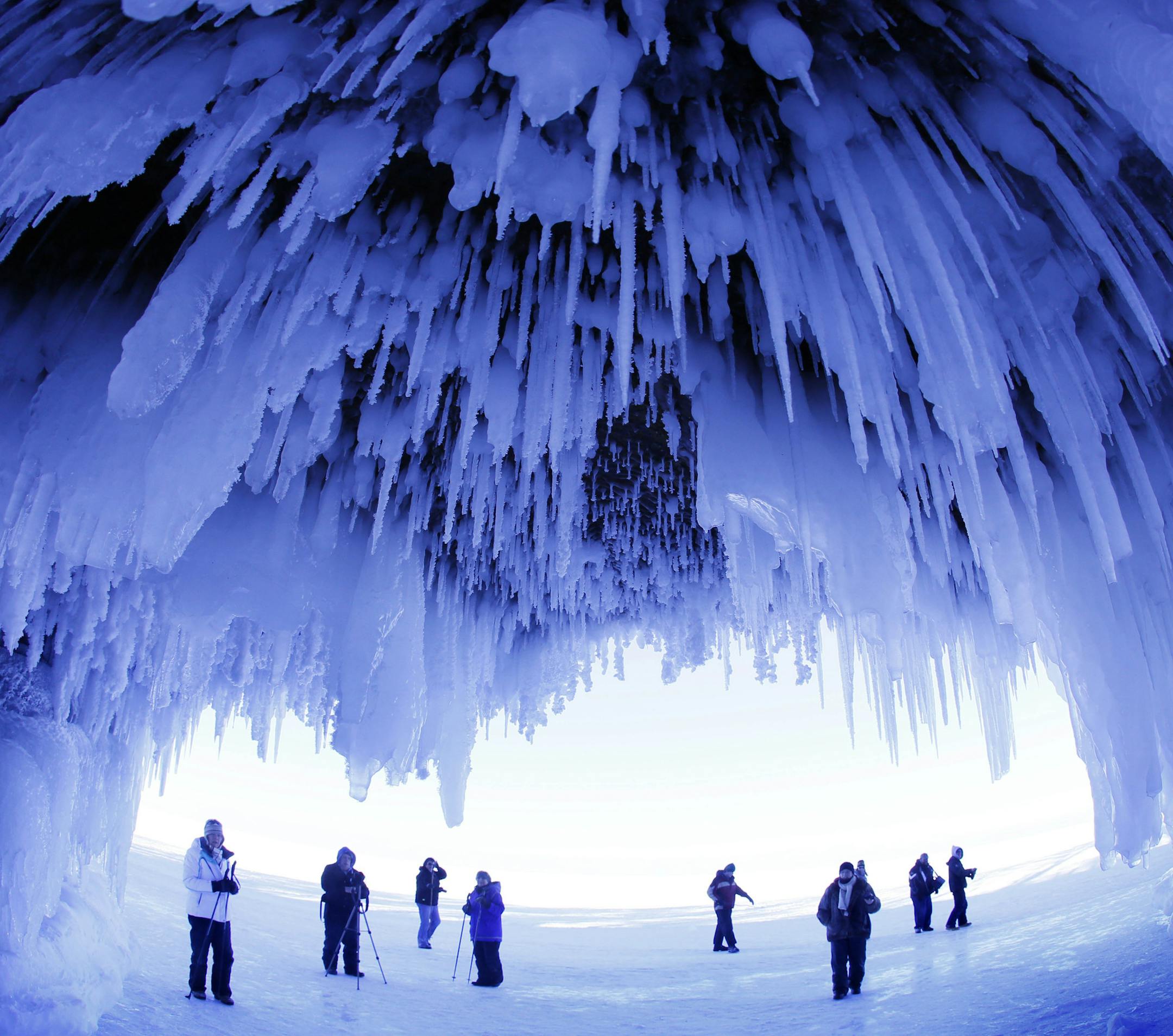 FILE - In this Feb. 2, 2014 file photo, people visit the caves at Apostle Islands National Lakeshore in northern Wisconsin, transformed into a dazzling display of ice sculptures by the arctic siege gripping the Upper Midwest. The caves are usually accessible only by water, but continued calm and cold weather could create the right conditions for people to access the ice caves on Lake Superior in early 2015. (AP Photo/Minneapolis Star Tribune, Brian Peterson)