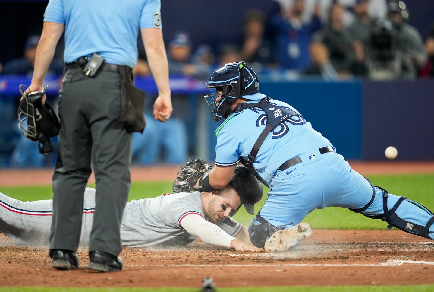 Ryan Jeffers scored on a sacrifice fly by Michael A. Taylor, while Blue Jays catcher Alejandro Kirk makes a tag without the ball during the 10th inning Friday