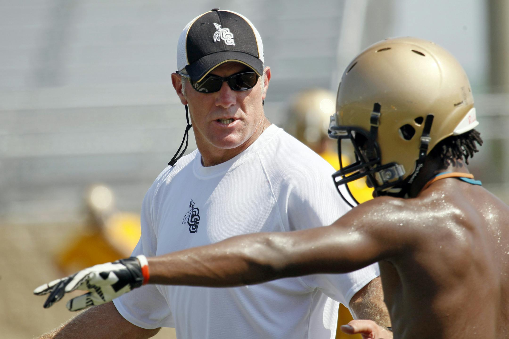 Former NFL quarterback Brett Favre, left, now an assistant football coach at Oak Grove High School.