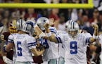Dallas Cowboys quarterback Tony Romo (9) celebrates as teammate Dan Bailey (5) is congratulated after kicking the game-winning field goal during overt