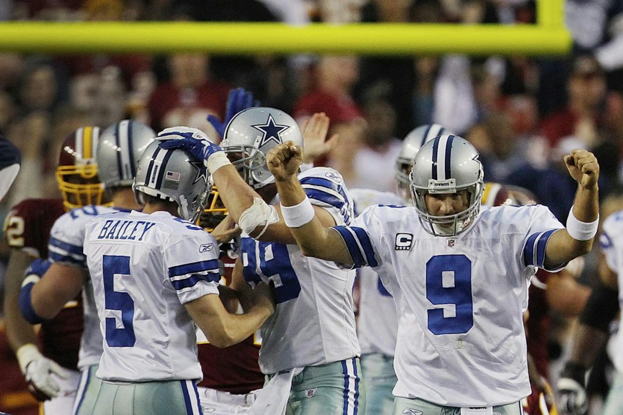 Dallas Cowboys quarterback Tony Romo (9) celebrates as teammate Dan Bailey (5) is congratulated after kicking the game-winning field goal during overtime of an NFL football game against the Washington Redskins in Landover, Md., on Sunday, Nov. 20, 2011. The Cowboys won 27-24.