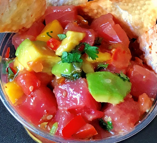 Ahi Tuna Poke Bowl: Ahi tuna, avocado, mango and pico de gallo tossed in a Hawaiian ginger-soy sauce served cold over rice with a fried wonton. At Caf
