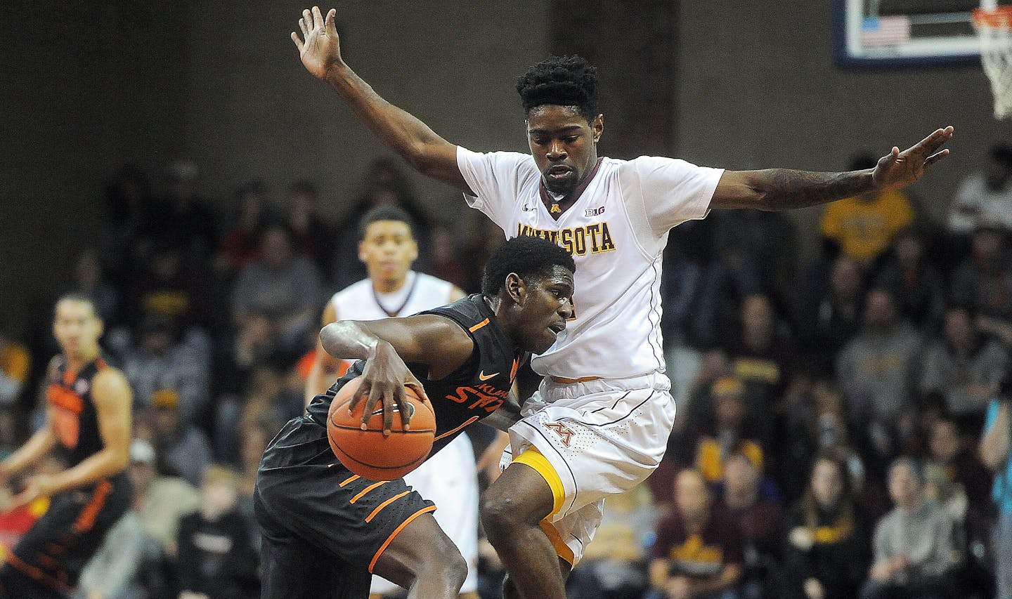 Oklahoma State's Jawun Evans dribbles the ball up the court while Minnesota's Kevin Dorsey guards at the Sanford Pentagon in Sioux Falls on Saturday, Dec. 12, 2015. (Jay Pickthorn/The Argus Leader via AP)