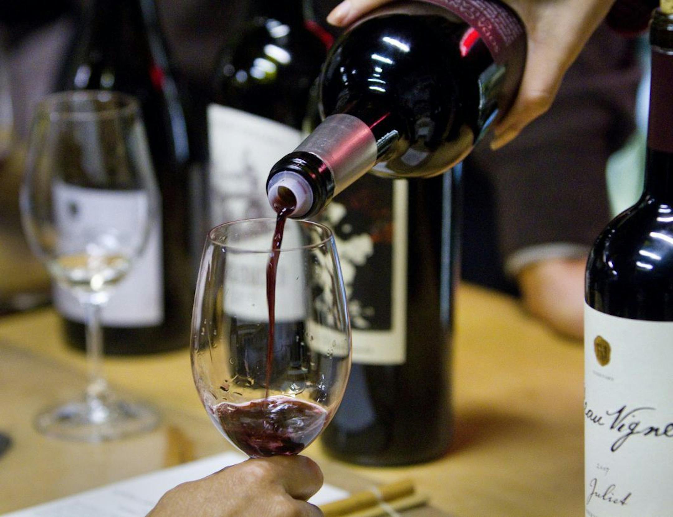Christine Tran, a certified sommelier, pours a glass of wine during a wine tasting at Artisan Wine Depot, in Mountain View, California, November 6, 2009. Women have smashed every glass ceiling in the wine world, from managing vineyards to crafting cult wines.