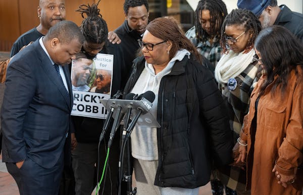Pastor Madalyn Fields of Immanuel Baptist Tabernacle prayed with the family of Ricky Cobb ll during a news conference at the Hennepin County Governmen
