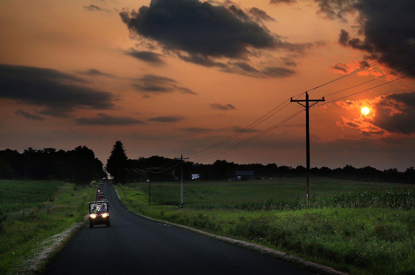 The sun set behind riders from the Luck Area ATV Club as they rode along a county road in rural Wisconsin.] JIM GEHRZ &#x201a;&#xc4;&#xa2; jgehrz@startribune.com / Luck, WI 7/31, 2014 / 7:00 PM / BACKGROUND INFORMATION: Ride-a-long with members of the Luck Area ATV Club, along the roads of Polk County, WI., where riding of the vehicles is allowed on some county roads. ORG XMIT: MIN1410011448080320