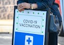 A woman leans on a COVID-19 vaccine registration sign at a back-to-school vaccine fair in West Baltimore, Maryland. Especially since the arrival of CO