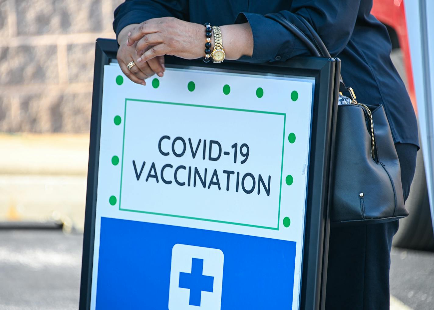 A woman leans on a COVID-19 vaccine registration sign at a back-to-school vaccine fair in West Baltimore, Maryland. Especially since the arrival of COVID-19 vaccines and the delta variant, kids' prospects for getting the disease rest largely on the decisions made by the adults who surround them, a CDC study shows. (Ulysses Munoz/The Baltimore Sun/TNS) ORG XMIT: 26088638W