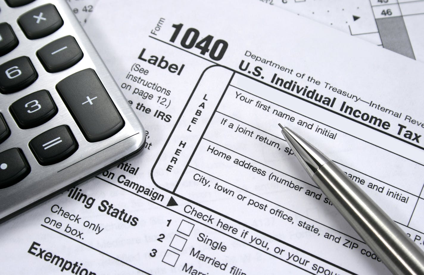 iStockphoto.com A 1040 Individual tax form with calculator and pencil.