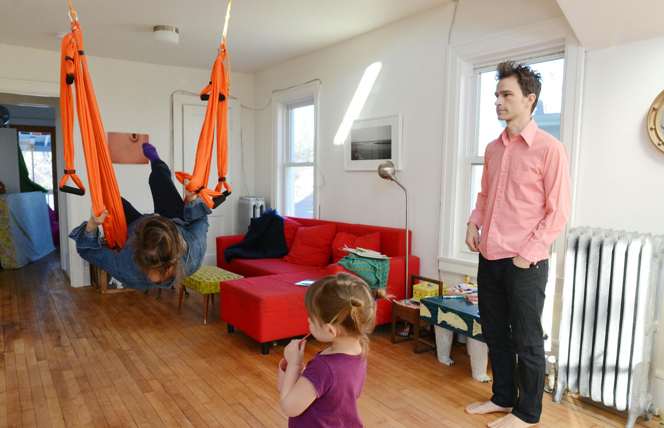 Olive Bieringa used the yoga hammock that hangs in their living room, as Otto Ramstad and their daughter, Uma, watched.