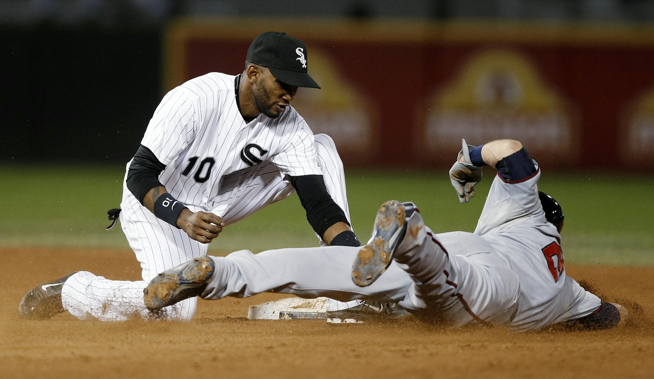 Chicago White Sox shortstop Alexei Ramirez tags out Minnesota Twins' Brian Dozier on an attempted stolen base during the fifth inning of a baseball game Tuesday, Sept. 17, 2013, in Chicago.