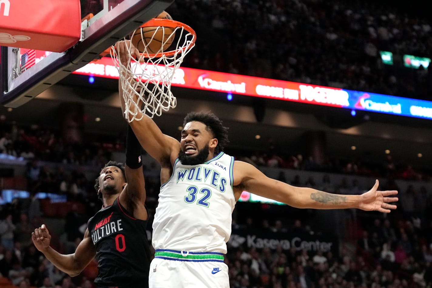 Minnesota Timberwolves center Karl-Anthony Towns (32) goes to the basket and is fouled by Miami Heat guard Josh Richardson (0) during the first half of an NBA basketball game, Monday, Dec. 18, 2023, in Miami. (AP Photo/Lynne Sladky)