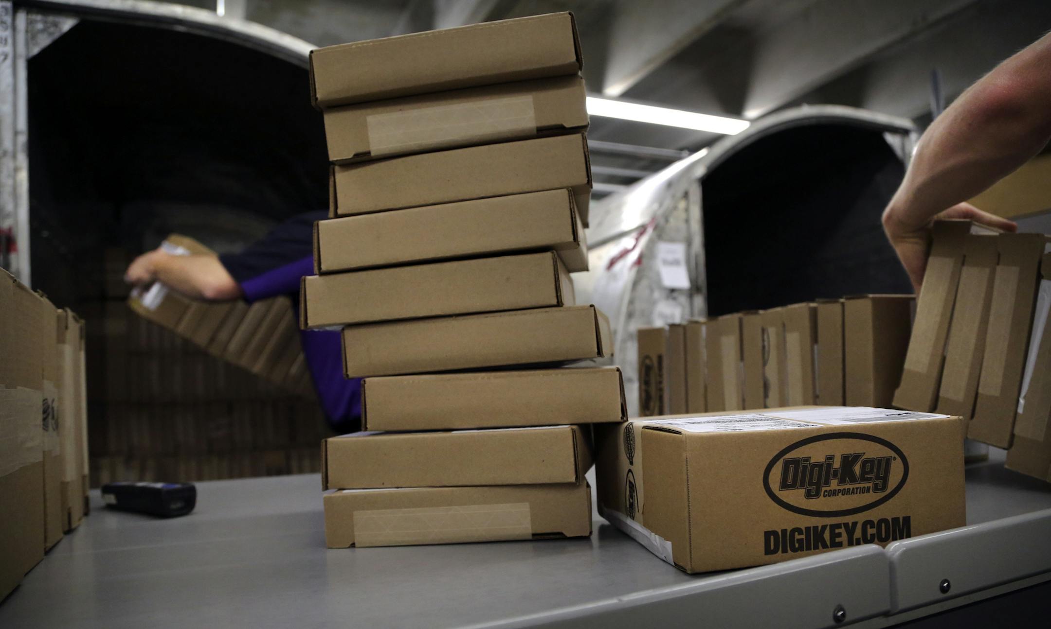 FedEx employee James Mathrews, left, loads a shipping pod up with packages from Digi-Key bound for customers from 170 countries around the world at the Digi-Key warehouse Tuesday, May 14, 2013 in Thief River Falls, MN. So many packages are shipped out of Digi-Key that FedEx, UPS and DHL have shipping operations set up inside Digi-Key.](DAVID JOLES/STARTRIBUNE) djoles@startribune Pennington County is an island of growth in a sea of economic contraction in northwest Minnesota. Since 2000, job grow