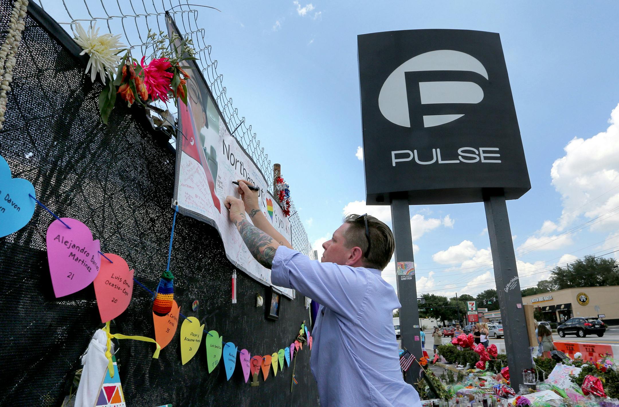 Eric Sorenson pays his respects as visitors flock to the roadside memorial at the Pulse nightclub on Wednesday, June 29, 2016 in Orlando, Fla. The city of Orlando has reached a deal to buy the Pulse nightclub and plans to transform the site of the deadliest mass shooting in U.S. history into a memorial. (Joe Burbank/Orlando/TNS)