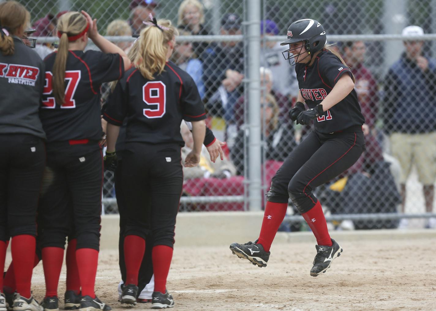 Elk River 's Jayme Langbehn hopped to home plate as her team waited for her after hitting a three-run home run in the sixth inning during the state Class 3A semifinals in softball at Caswell Park in North Mankato Min., Thursday, June 6, 2013. Elk RIver won 9-3 over Forest Lake ] (KYNDELL HARKNESS/STAR TRIBUNE) kyndell.harkness@startribune.com