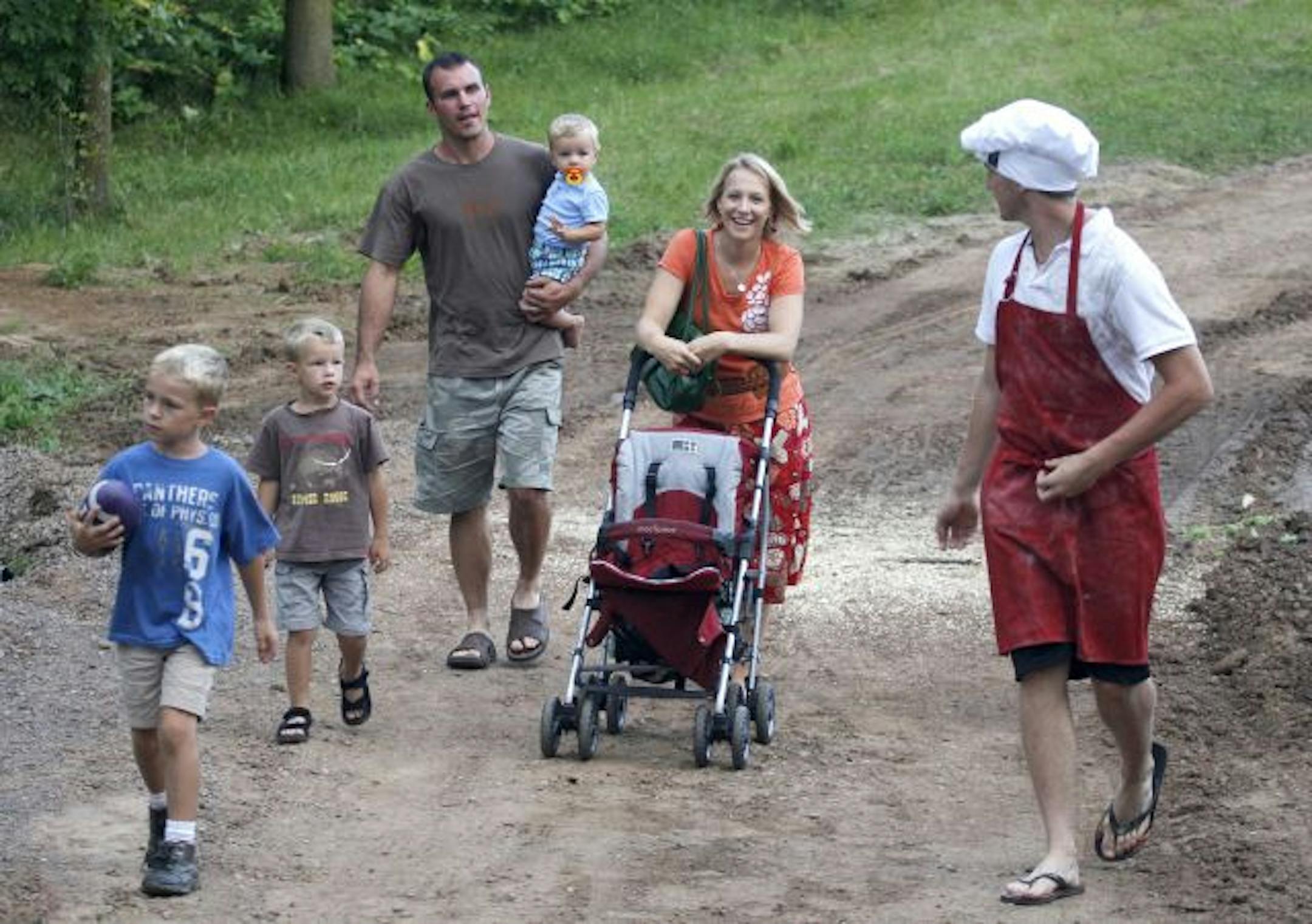 Andy Falk, right, leads the Teichroew family of Minneapolis from their car down to "the grotto" at LoveTree Farmstead for pizza. From left: sons Caeden and Carsen, parents Josh (with infant Colten) and Becky. The Falk family emphasizes their farm's rustic assets. "We have funk," said Mary Falk with a laugh.