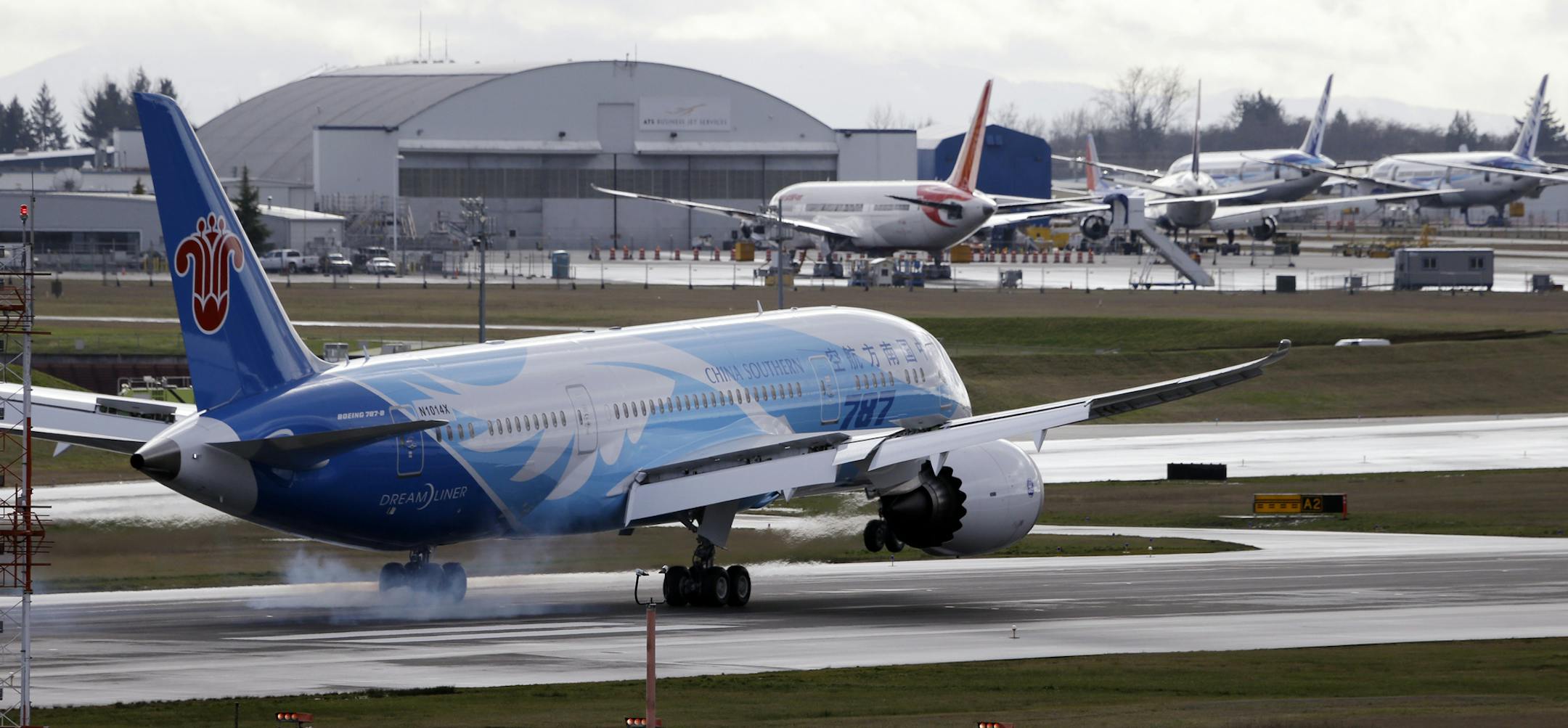 A Boeing 787 jet touches down Thursday in view of parked 787's at Paine Field in Everett, Wash., following a flight from Texas.