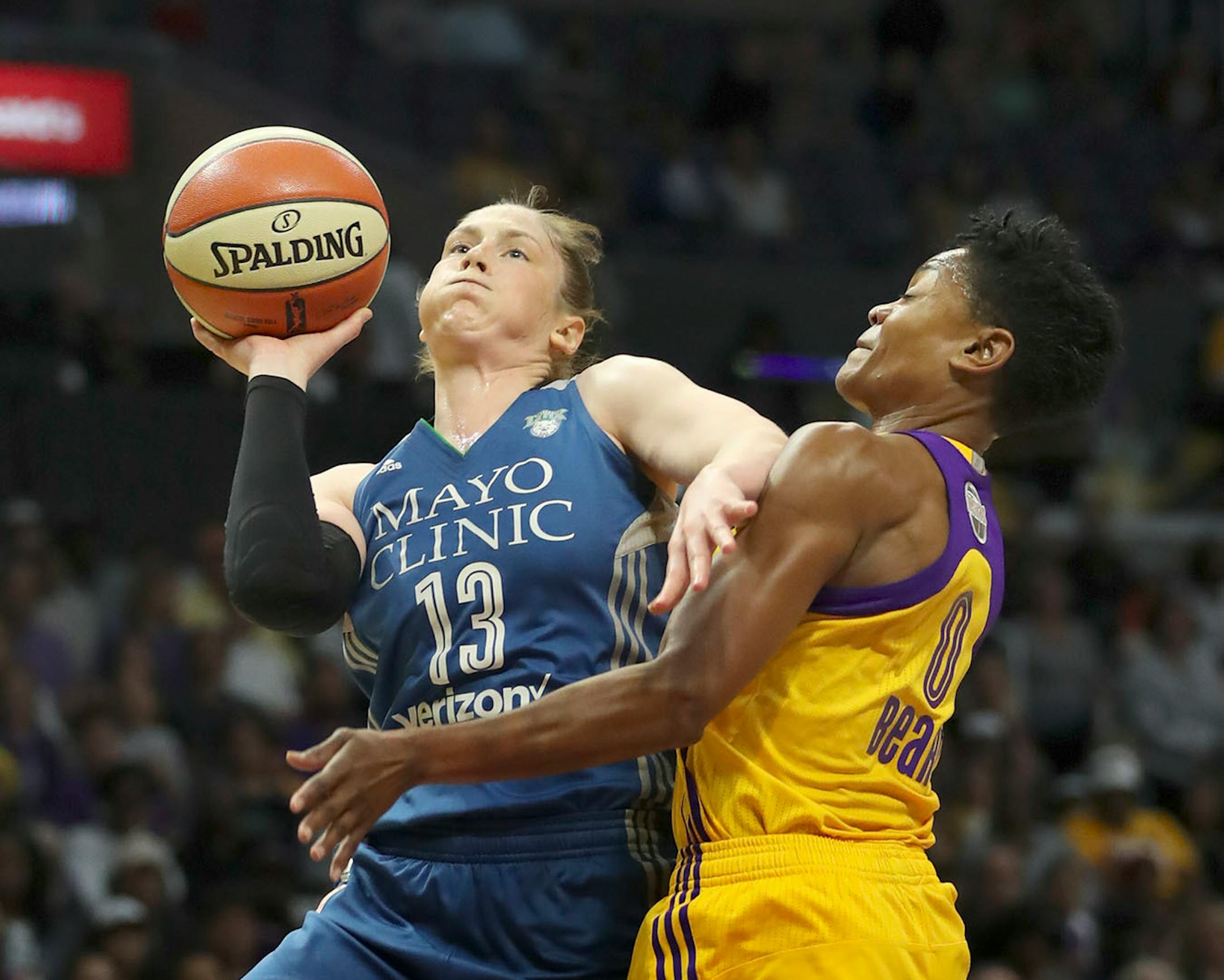 Minnesota Lynx guard Lindsay Whalen (13) got a first quarter shot off despite the defense of Los Angeles Sparks guard Alana Beard (0).