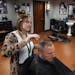 Master barber Erin Diede gives a haircut to Kent Whitworth, director and CEO of the Minnesota Historical Society, on Thursday, April 7, at Capitol Bar