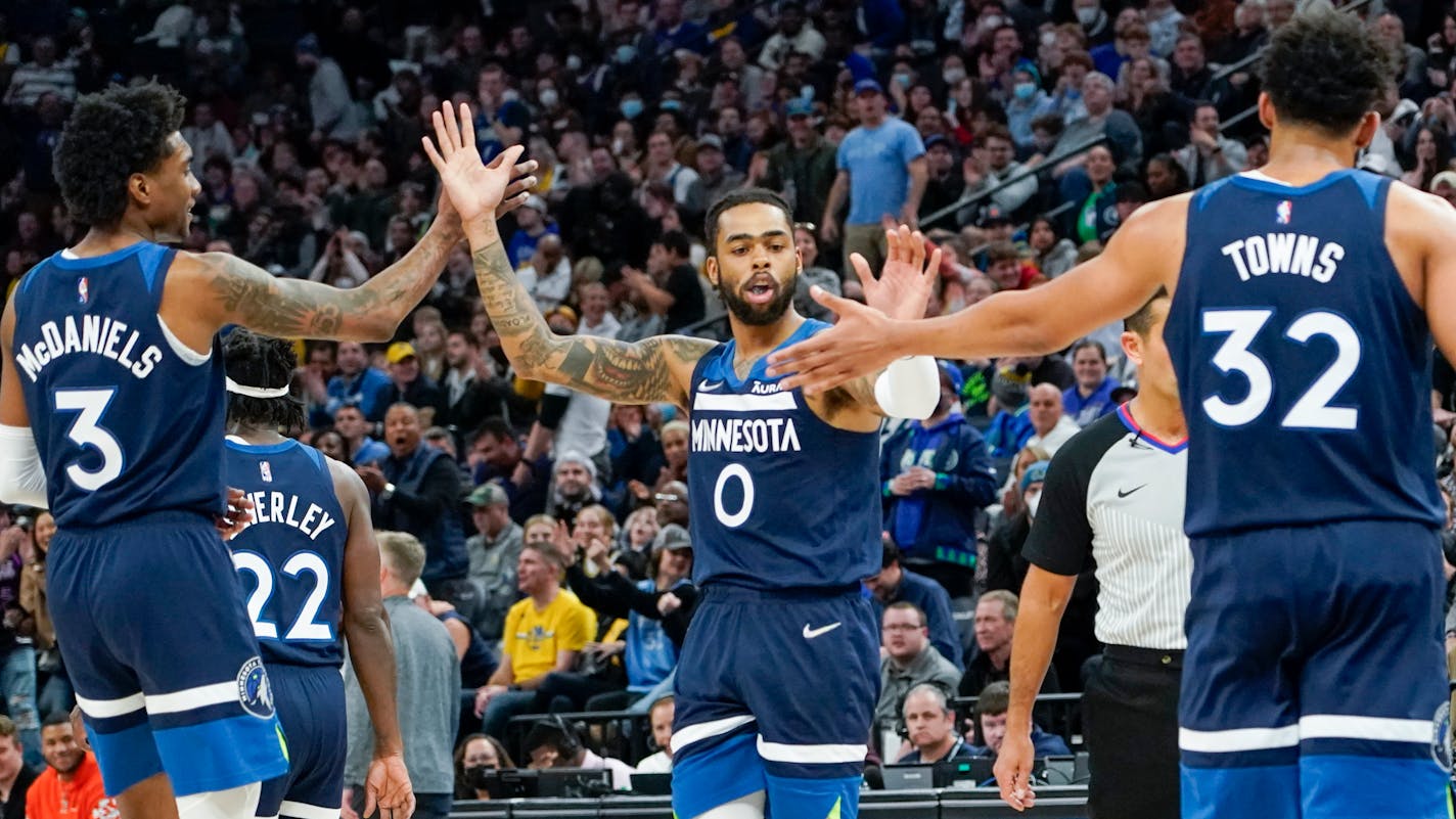 Minnesota Timberwolves guard D'Angelo Russell, (0) gets high-fives from forward Jaden McDaniels (3) and center Karl-Anthony Towns (32) during the second half of an NBA basketball game Tuesday, March 1, 2022, in Minneapolis. The Timberwolves won 129-114. (AP Photo/Craig Lassig)