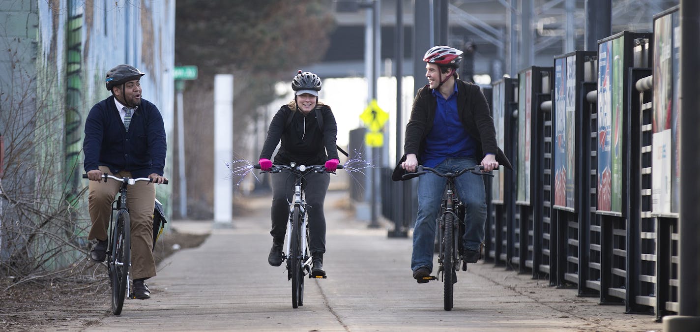 Alexis Pennie, from left, Amy Brugh and Ethan Fawley, ride on the Hiawatha Bike Trail past the Cedar Riverside LRT station in Minneapolis on Friday, March 13, 2015. Hawley is the executive director of Minneapolis Bicycle Coalition, and Pennie and Brugh are volunteers. ] LEILA NAVIDI leila.navidi@startribune.com /