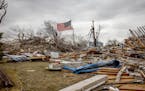A flag was placed in the middle of the rubble left from a tornado touchdown in Taopi, Minn., on Thursday, April 14, 2022.