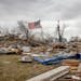 A flag was placed in the middle of the rubble left from a tornado touchdown in Taopi, Minn., on Thursday, April 14, 2022.