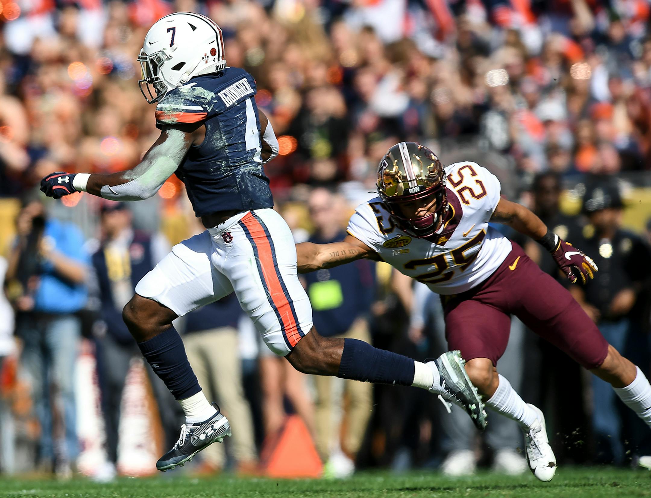 Auburn Tigers defensive back Noah Igbinoghene (4) returned a punt for a touchdown as Minnesota Gophers defensive back Benjamin St-Juste (25) was unable to make the tackle in the first quarter.