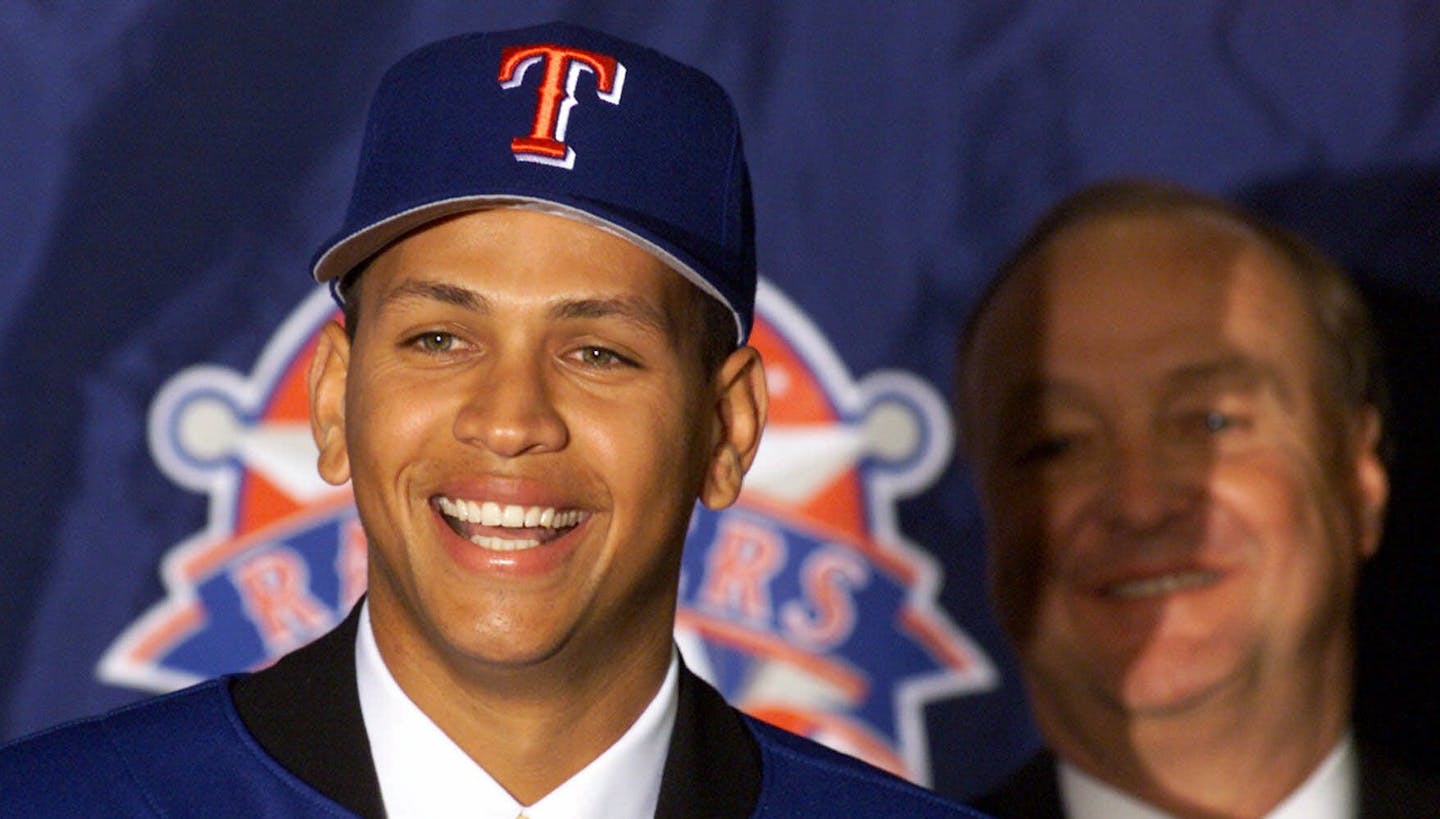 FILE--Shortstop Alex Rodriguez gives reporters a big smile while answering questions about his $252 million 10-year deal with the Texas Rangers during a news conference in Arlington, Texas, Tuesday, Dec. 12, 2000. Looking on in background is Rangers owner Tom Hicks. (AP Photo/Donna McWilliam) ORG XMIT: NY170