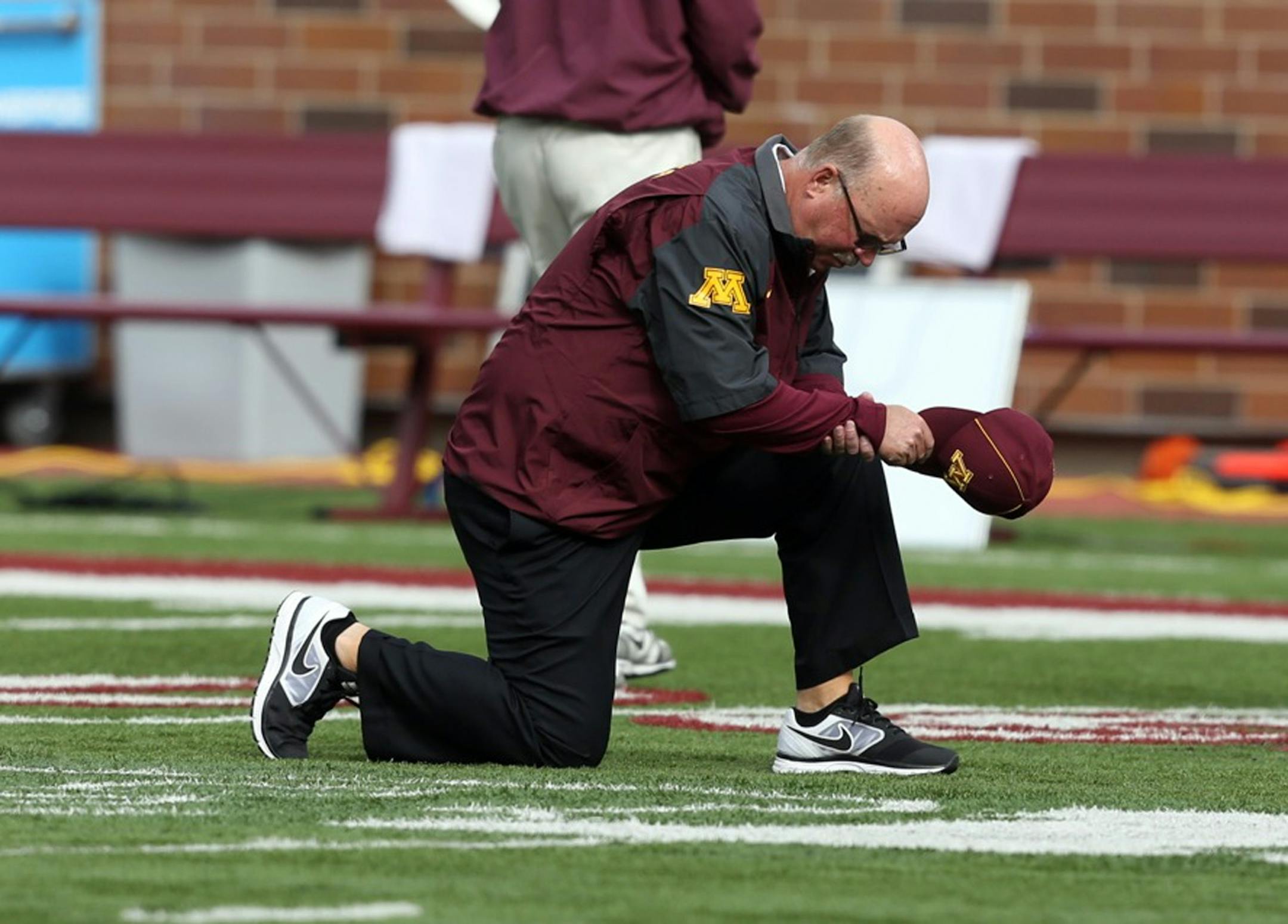 Gopher football coach Jerry Kill prays with the team . Last week he left the game at the half because of a siezure.