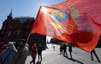 Communists party supporters gather with a red flag decorated with Soviet Union Emblem to mark Labour Day, also knows as May Day near Red Square with t