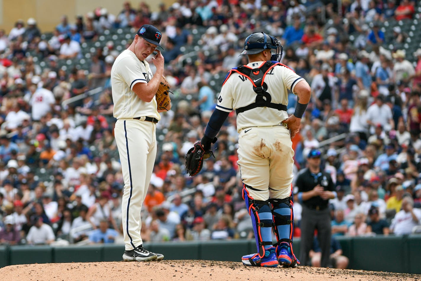 Minnesota Twins pitcher Louie Varland, left, takes a moment with catcher Christian Vazquez after giving up two home runs in a row against the Detroit Tigers during the fifth inning of a baseball game, Sunday, June 18, 2023, in Minneapolis. (AP Photo/Craig Lassig)