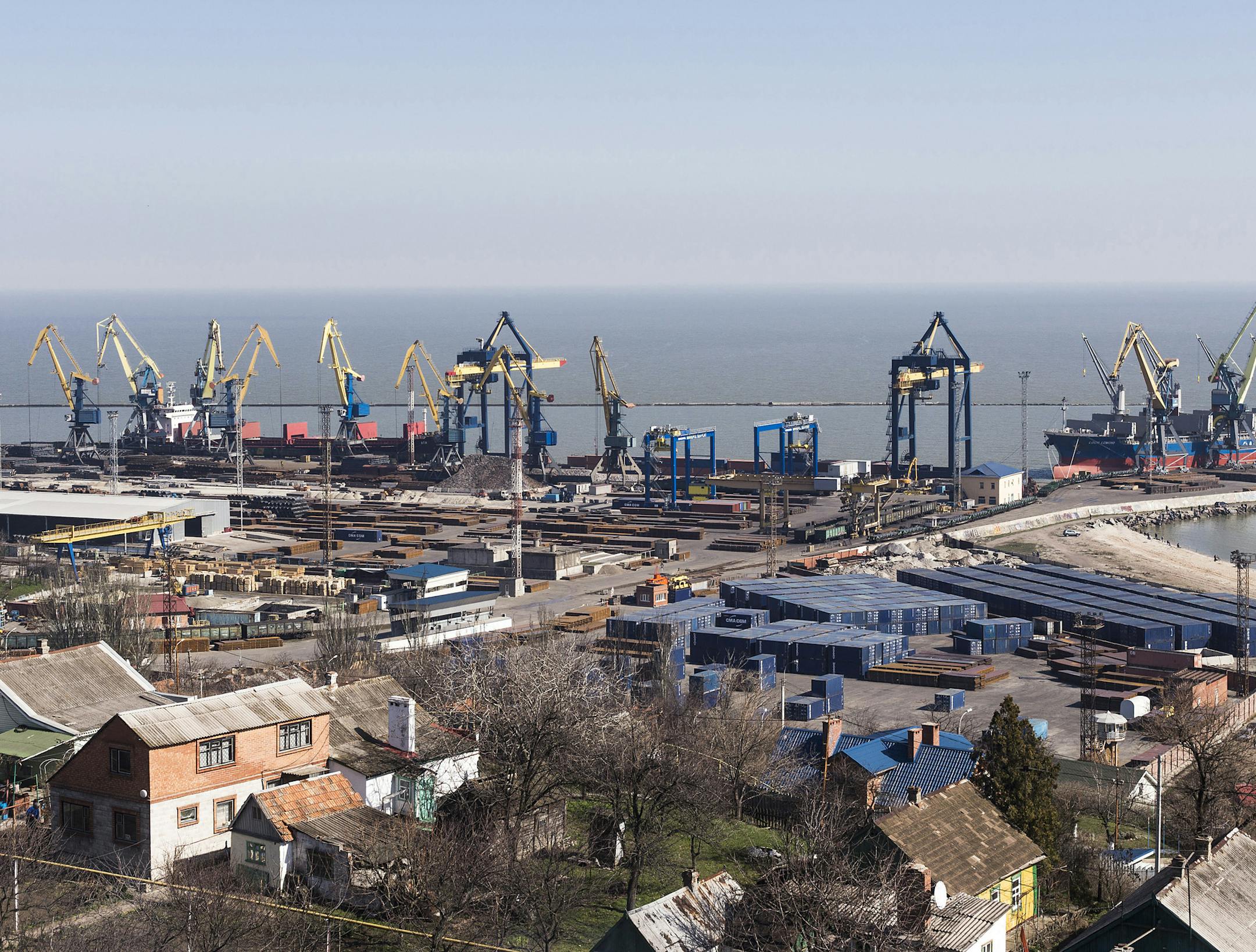 Shipping cranes stand on the dockside near stores of steel awaiting export at the Port of Mariupol, one of Ukraine's biggest commercial sea ports, in Mariupol, Ukraine, on March 24, 2014. MUST CREDIT: Vincent Mundy/Bloomberg ORG XMIT: 480923735