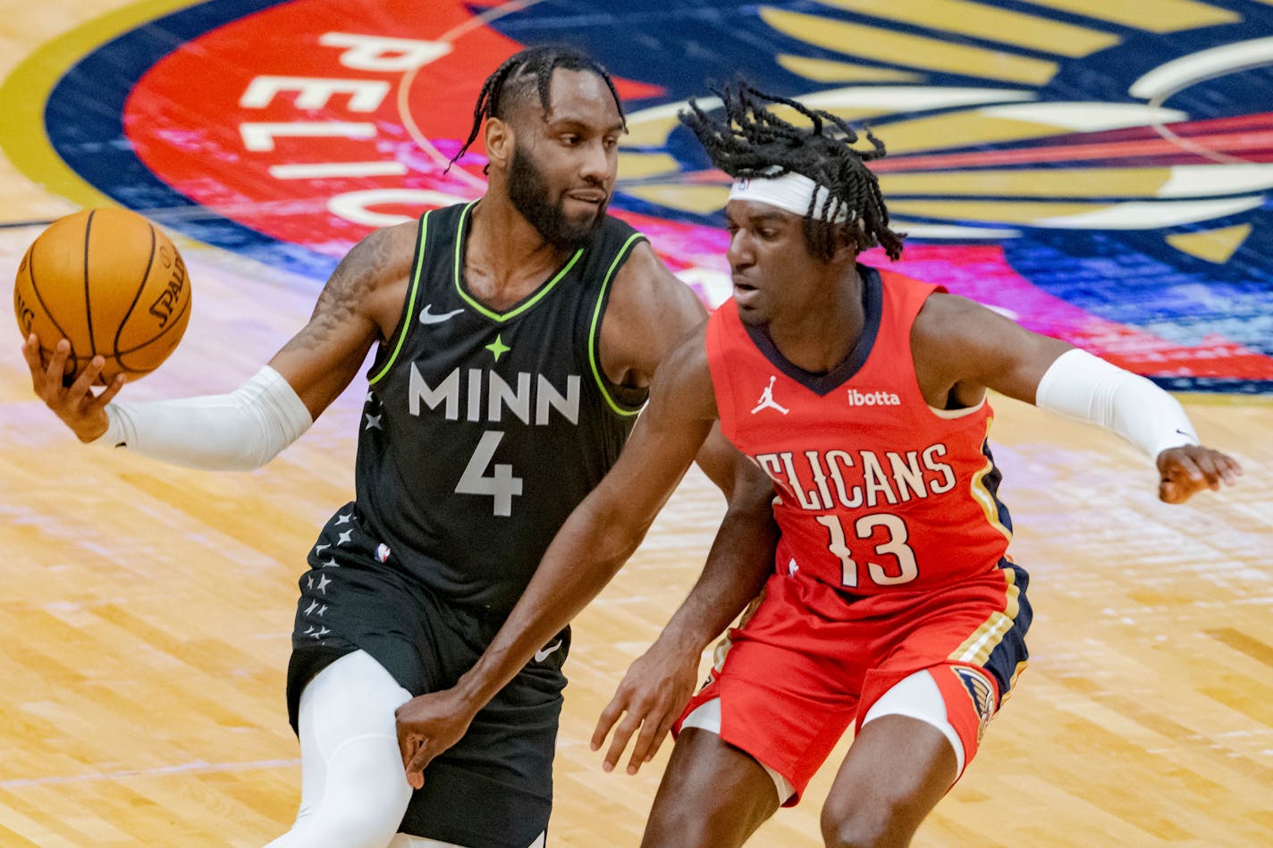 Minnesota Timberwolves guard Jaylen Nowell (4) dribbles around New Orleans Pelicans guard Kira Lewis Jr. (13) in the first half of an NBA basketball game in New Orleans, Thursday, March 11, 2021. (AP Photo/Matthew Hinton)