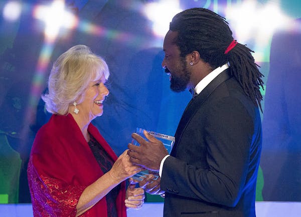 Britain's Camilla, Duchess of Cornwall presents the trophy to Marlon James, author of "A Brief History of Severn Killings", after he was named as the 