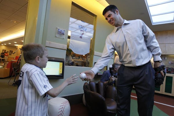 Joe Mauer passed a ball to Gillette patient Logan Swedberg Monday morning at a playroom he donated to Gillette Children's Hospital in St. Paul. The sp