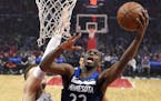 Minnesota Timberwolves forward Andrew Wiggins, right, shoots as Los Angeles Clippers forward Blake Griffin defends during the first half of an NBA bas