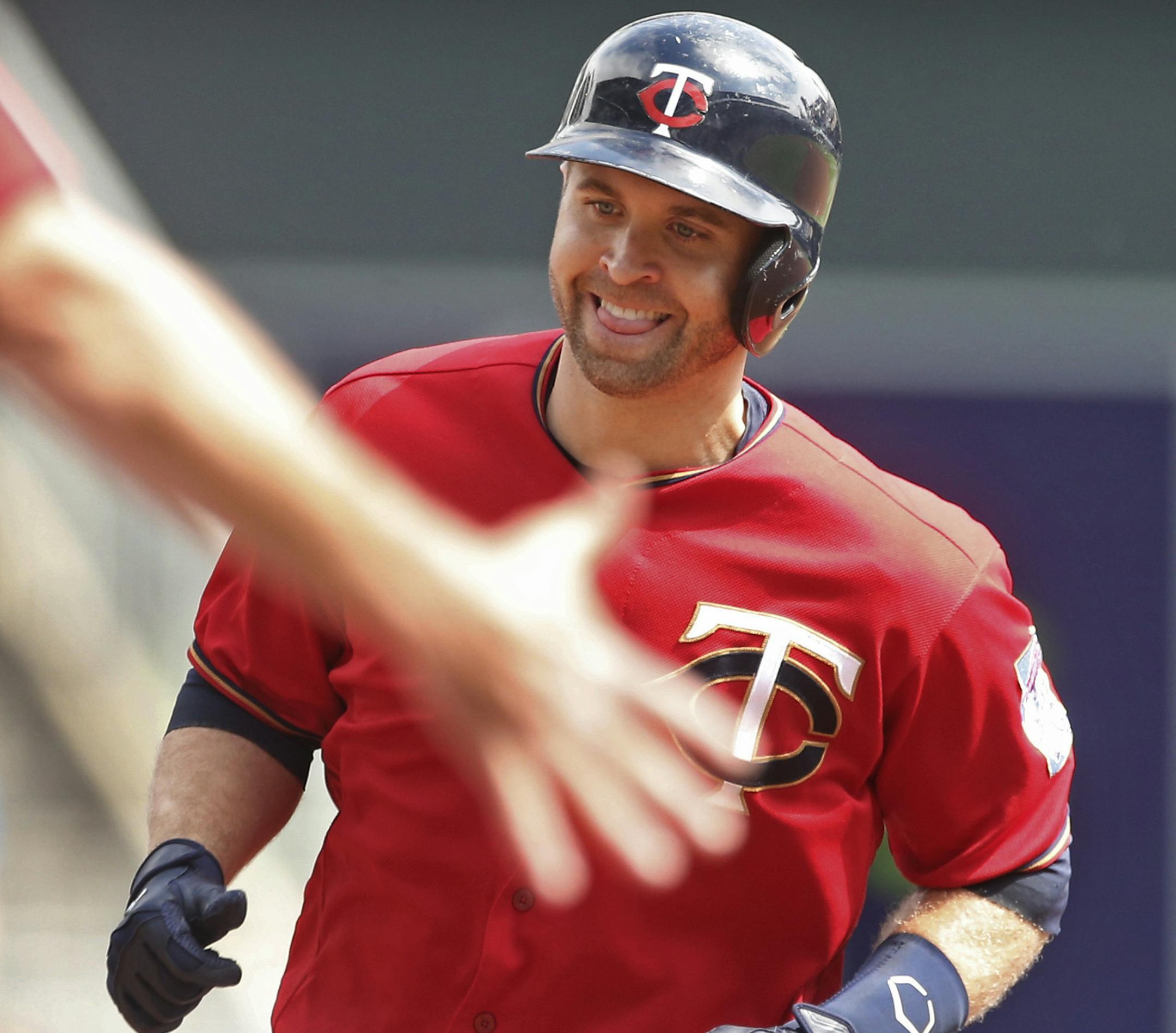 Minnesota Twins' Brian Dozier smiles as the third base coach reaches out to congratulate him as he jogs the base path on a solo home run off Kansas City Royals pitcher Ian Kennedy in the first inning of a baseball game Monday, Sept. 5, 2016, in Minneapolis. (AP Photo/Jim Mone)