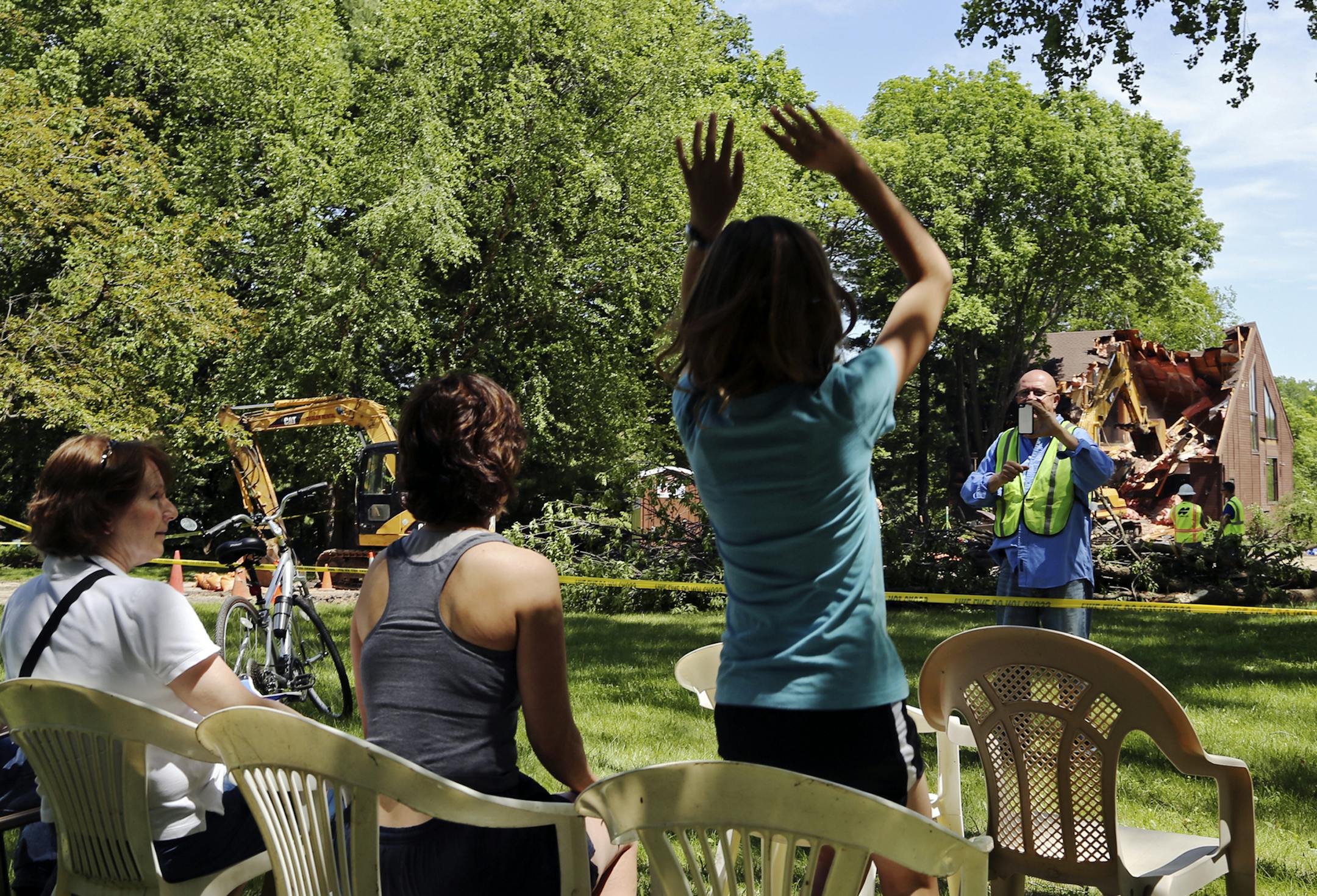 Crews work to demolish a home Tuesday, June, 3, 2014, in Eden Prairie, MN, that was declared uninhabitable due to the imminent risk of failure and collapse from damage sustained during the recent heavy rainfall. The home's owner, who did not give his name, was at the site briefly and said that while the situation was saddening the "city of Eden Prairie has been great." Neighbor Rick Perry hosted neighbors and media on his lawn to watch the demolition, and even snapped a photo of neighbors he ins