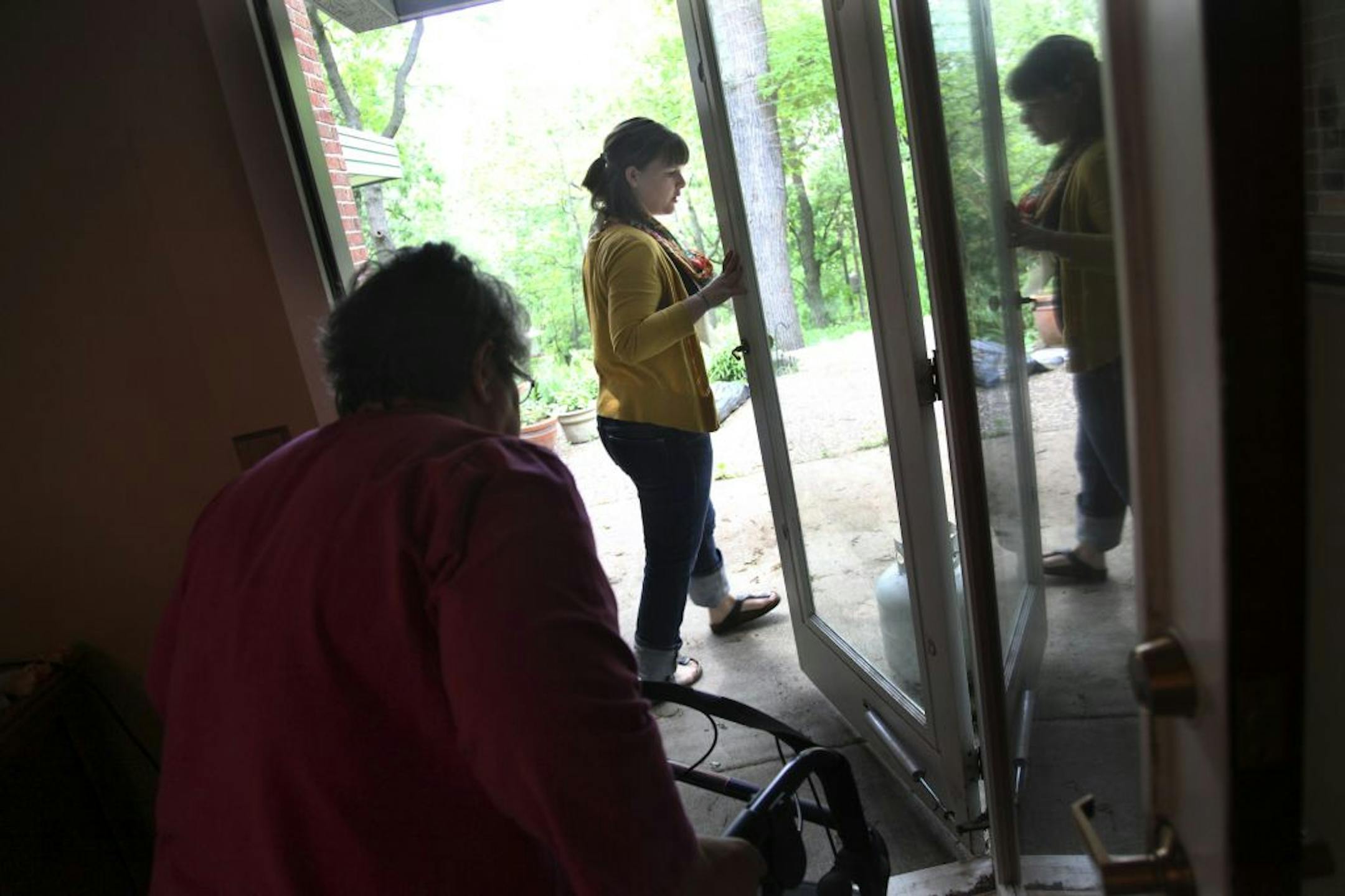 Deborah Peteler pays Laura Sampers, right, out of pocket for her work with Carmen Melendez, left.