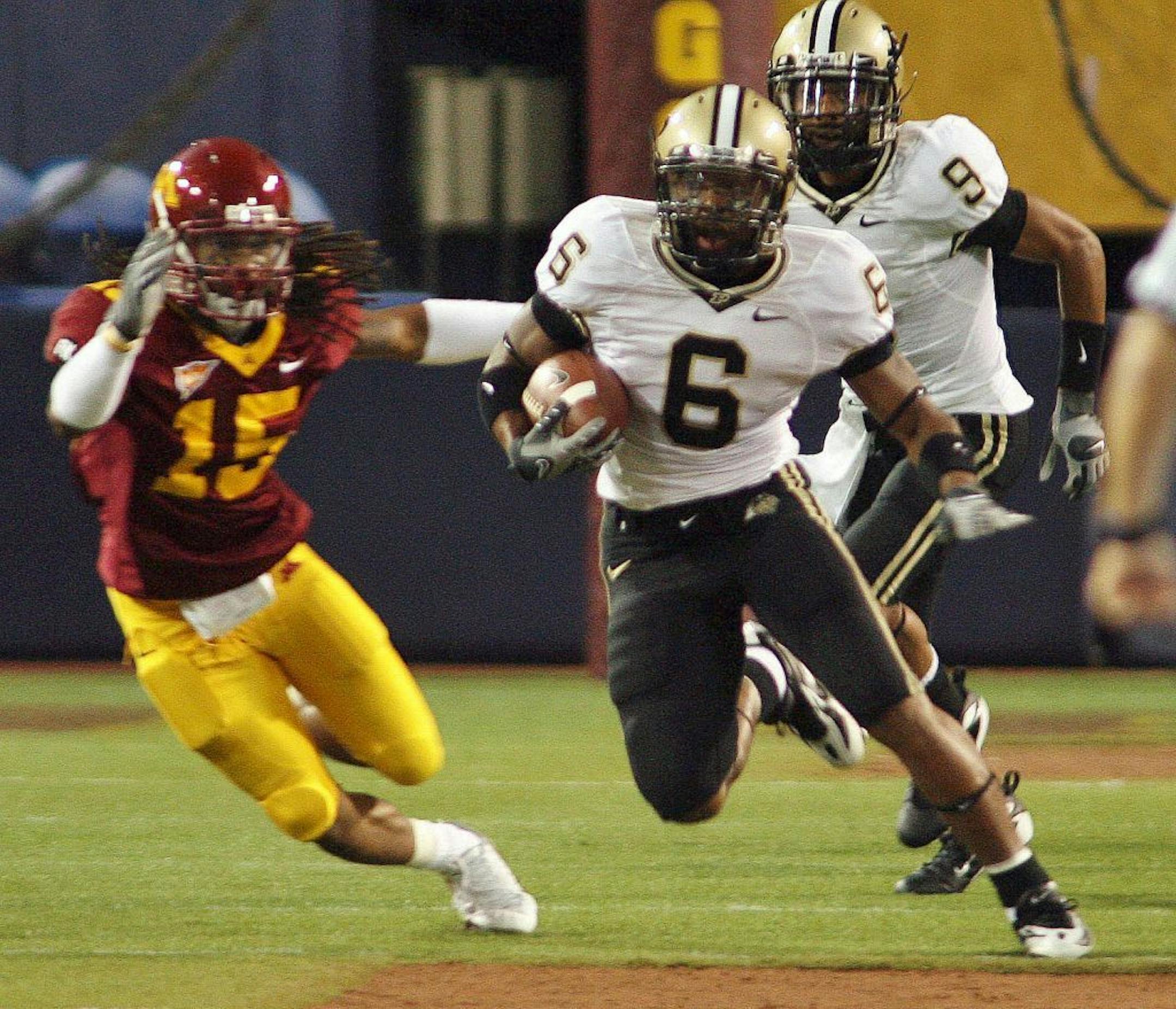 Purdue's Desmond Tardy #6 ran by Gophers Jamal Harris #15 on his way to a 95 yard opening kickoff return for a touchdown.
