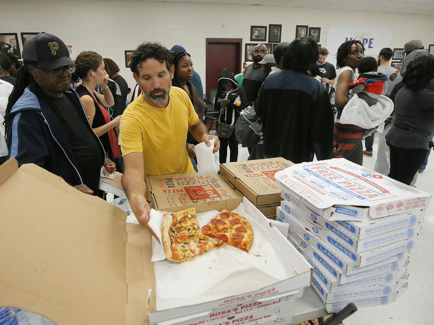 Angel Poventud, who voted early, volunteers his time to hand out pizza and snacks to people waiting in line. The wait time to vote at the Pittman Park precinct in Atlanta was reported to be three hours. Pizza and snacks were donated for the people waiting in line. (Bob Andres/Atlanta Journal-Constitution/TNS) ORG XMIT: 1244766