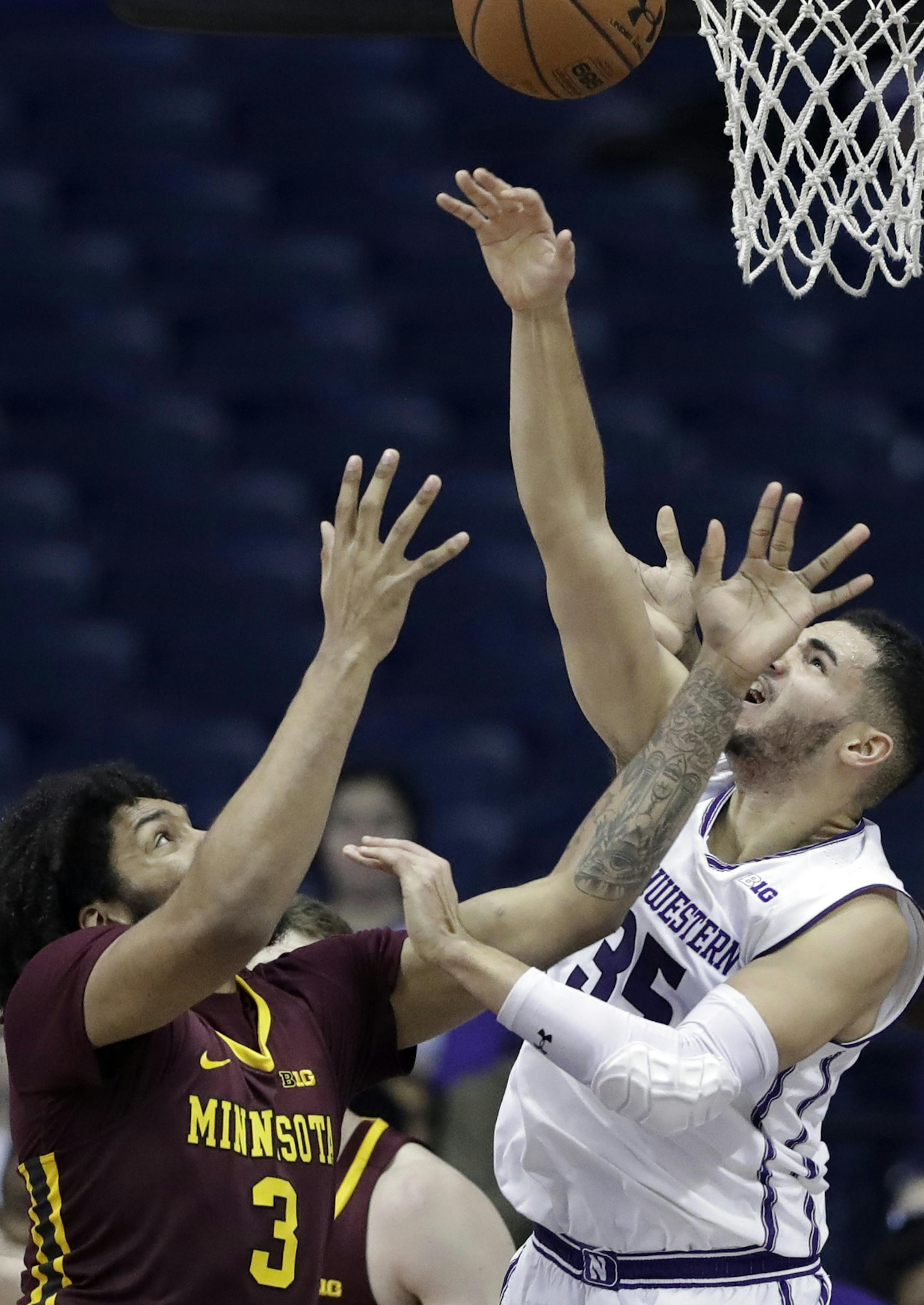 Northwestern guard Aaron Falzon, right, vies for a rebound against Minnesota forward Jordan Murphy during the second half of an NCAA college basketball game Wednesday, Jan. 10, 2018, in Rosemont, Ill. Northwestern won 83-60. (AP Photo/Nam Y. Huh)
