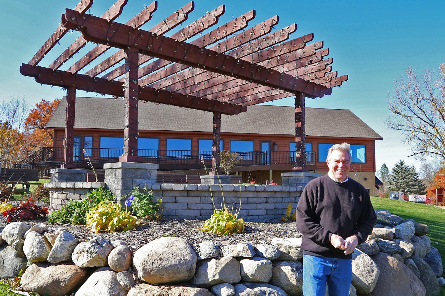 Minnesota Horse and Hunt Club co-owner Randy Travalia, with the rebuilt clubhouse behind him, as well as an outdoor wedding area. The club has hosted weddings with as many as 500 people attending.