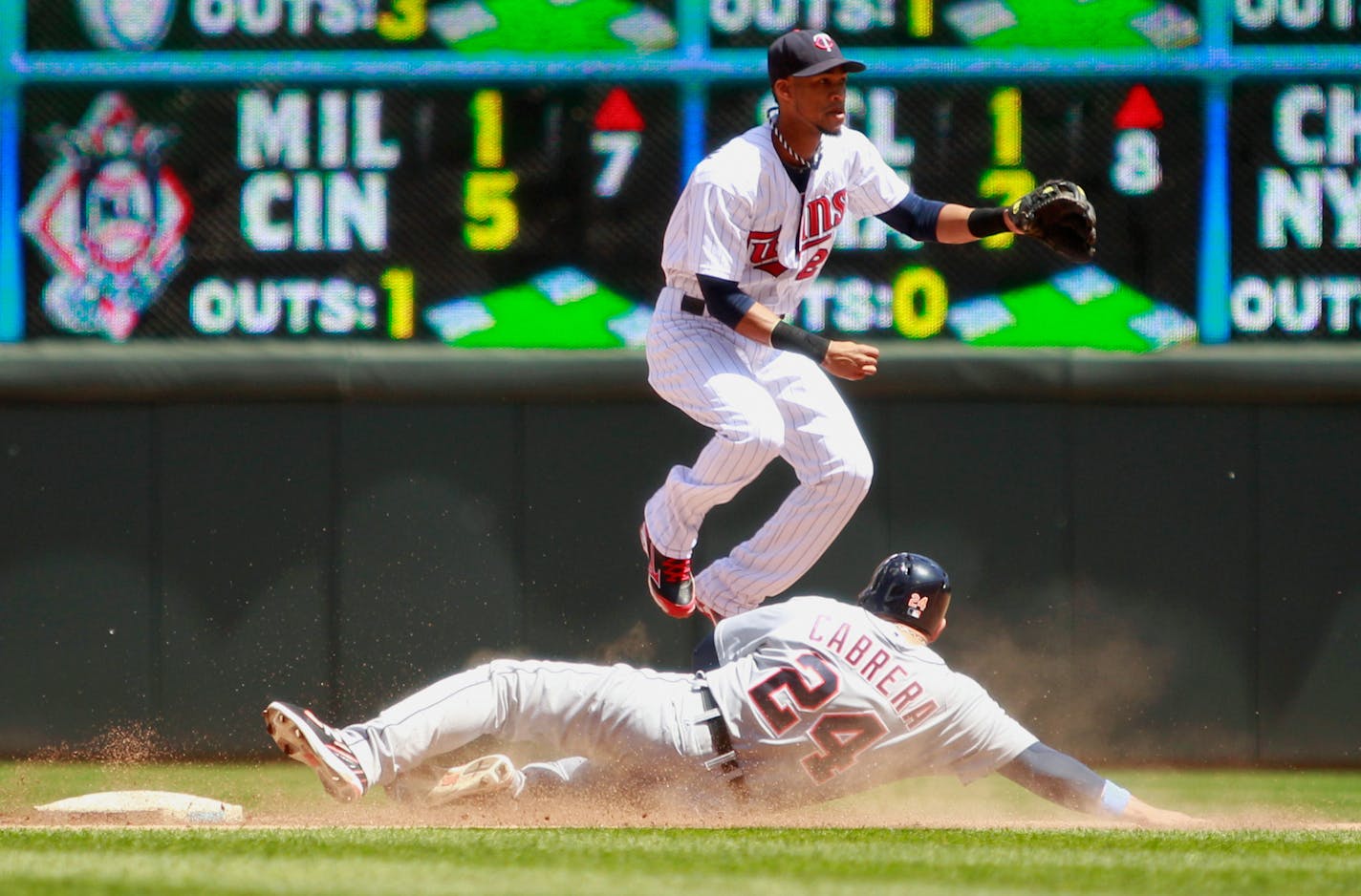 Minnesota Twins shortstop Pedro Florimon (25) jumps over Detroit Tigers' Miguel Cabrera (24) as he completes a double play during the fifth inning of a baseball game, Sunday, June 16, 2013, in Minneapolis. (AP Photo/Genevieve Ross)