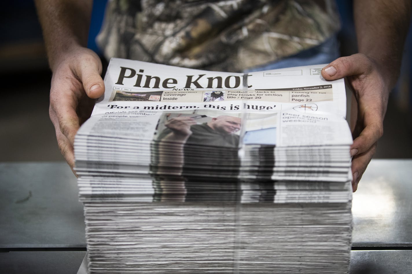 A mailroom associate at Star Printers in Cambridge stacks and binds freshly printed copies of the second issue of the Pine Knot News.