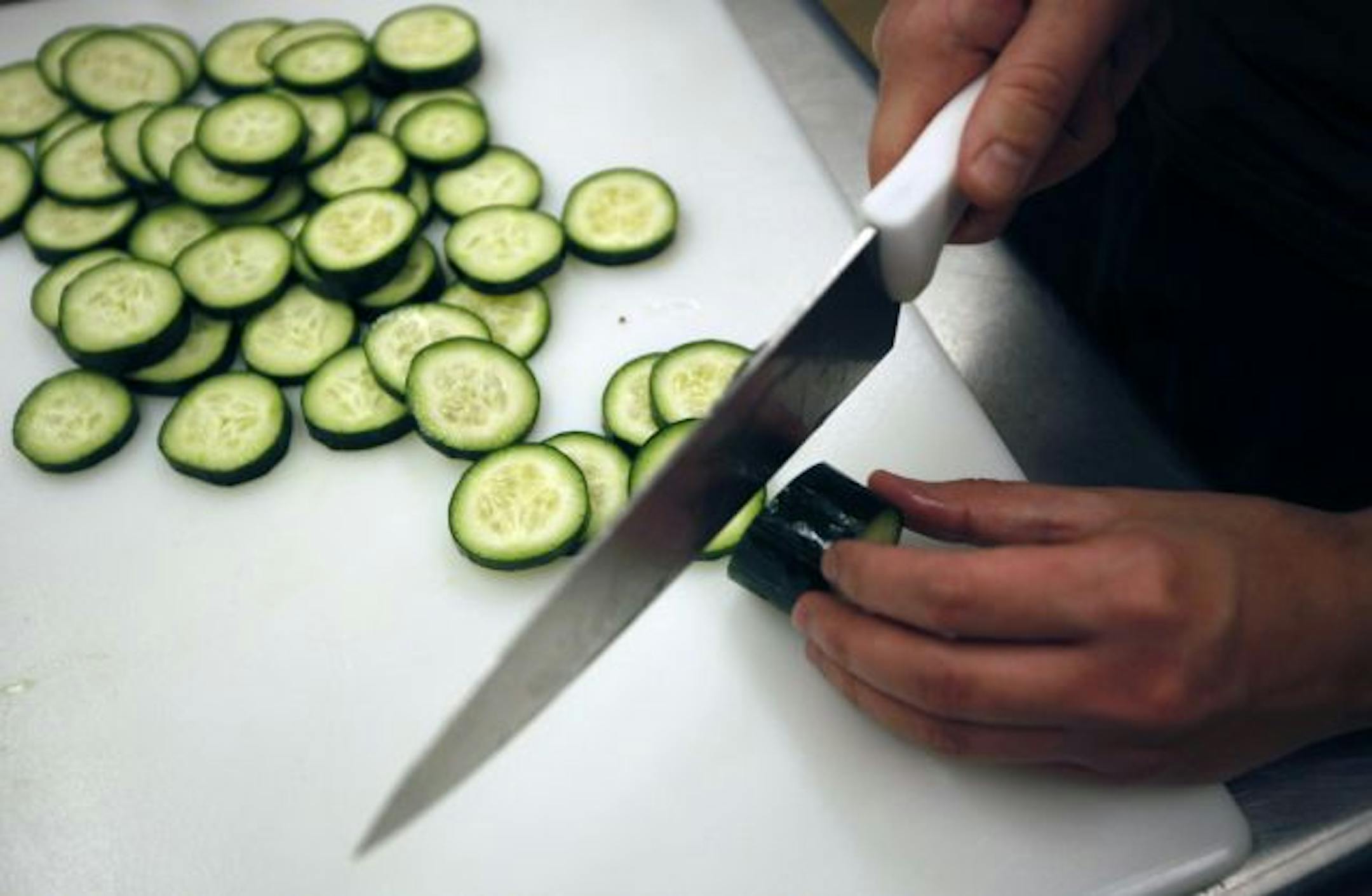 A partnership between Dakota County, School District 197 and the local Green Mill in Hastings has created a new cafeteria at the Judicial Center in Hastings. Student Cory Vinge cuts cucumbers for the lunch menu.