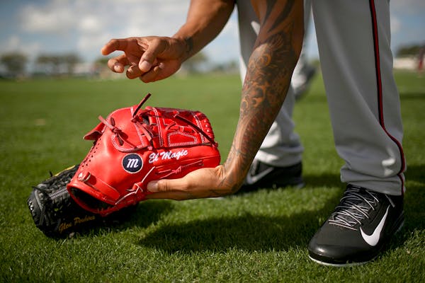 Twins pitcher Ervin Santana picked up his glove after stretching during a spring training workout in March.