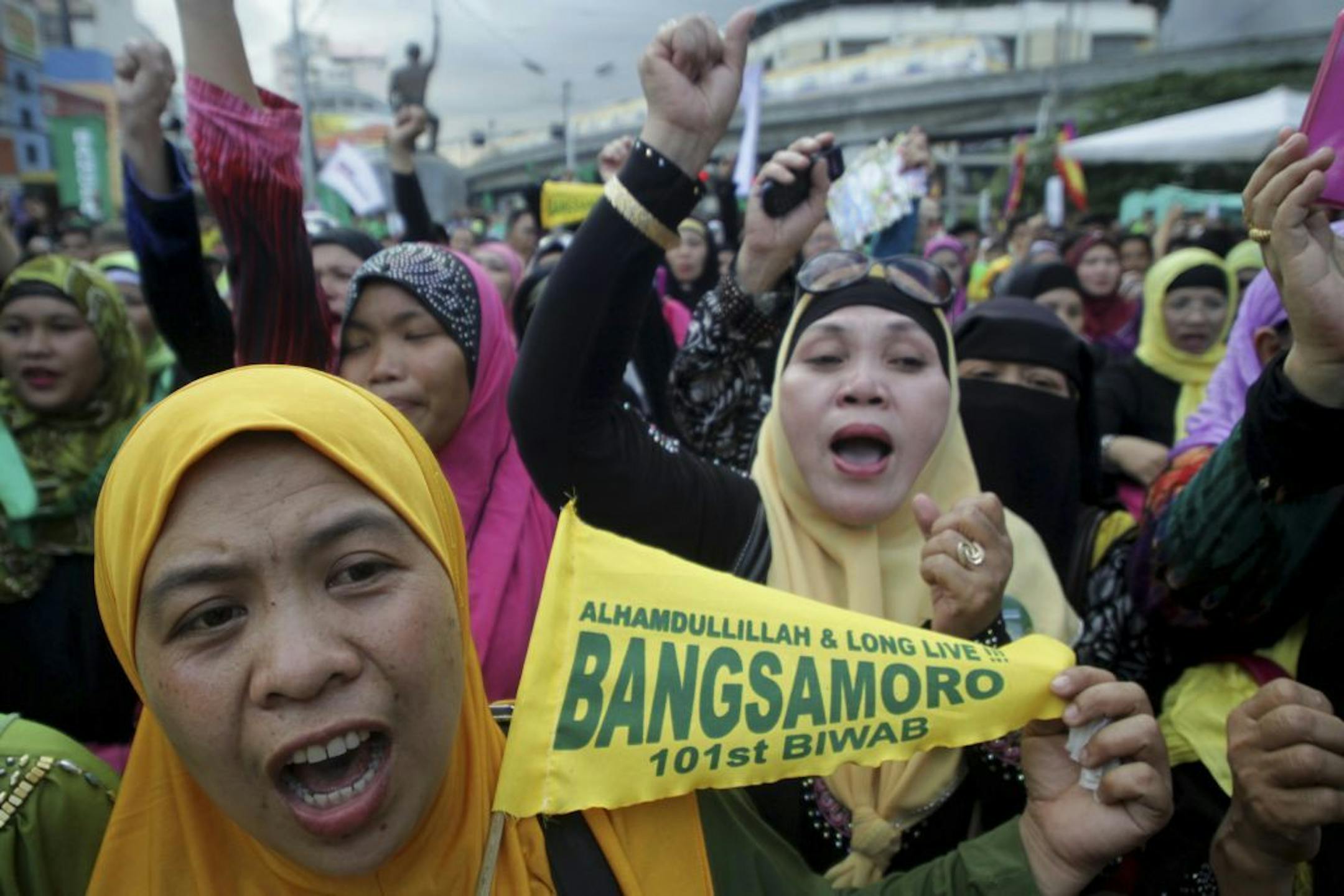 Filipino Muslims cheer after learning that a peace accord has been signed between Moro Islamic Liberation Front leaders and Philippine President Benigno Aquino III during a rally Thursday March 27, 2014 outside the presidential palace in Manila, Philippines.